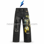 Front view of black graphic jeans with 5-pocket styling, faded wash, large right-leg artwork, and left-leg cross print