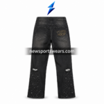 Side pose of black graphic jeans showing side seam, printed artwork panel, washed denim surface, and wide-leg fit