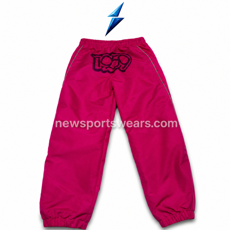 Pink windbreaker pant with elastic waist, side pockets, piping lines, and printed thigh logos