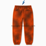 NSW Acid Wash Joggers front view in burnt orange and dark brown with Maritime crest, stencil leg print and cuffed ankles
