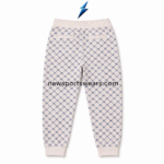 NSW cream jogger pants close-up showing the elasticated waistband, white drawstrings and navy printed fabric.